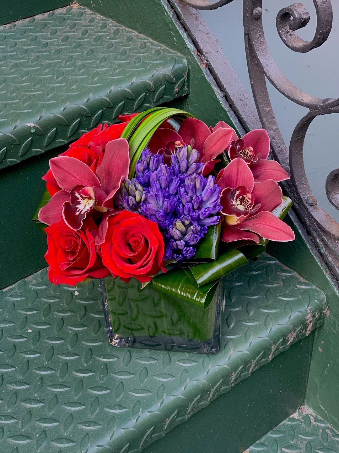 red rose, blue hyacinth, burgundy cymbidium, and modern leaf loops