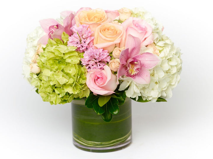 Peach Roses, pink Roses, peach spray Roses, white and green Hydrangea, and pink Cymbidium Orchids